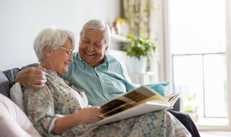 Proveer at Port City | Happy senior couple looking at memory book